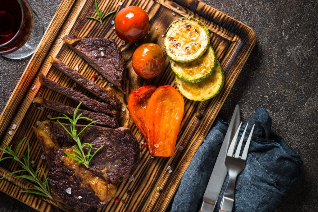 Grilled beef steak with vegetables top view