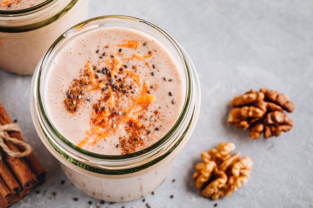 Healthy carrot cake smoothie with walnuts and chia seeds in glass jars