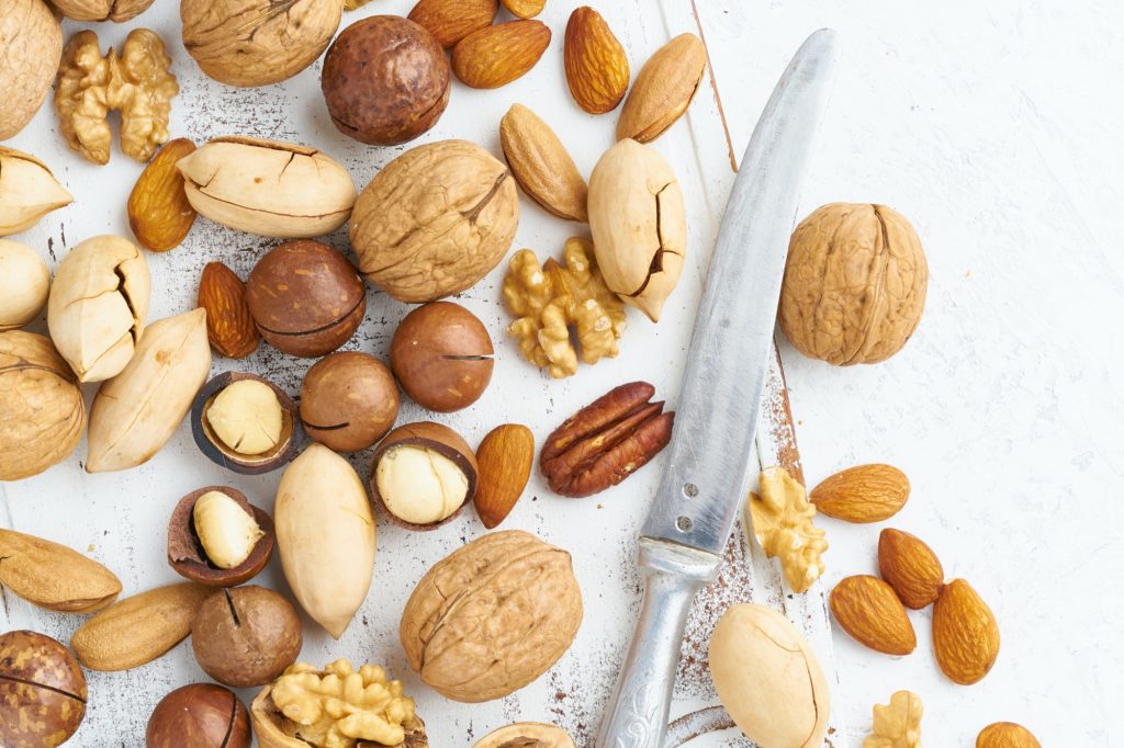 Mix of nuts - walnut, almonds, pecans, macadamia and knife for opening shell