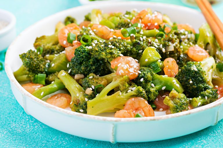 Stir fry shrimp with broccoli close up on a plate. Prawns and broccoli.